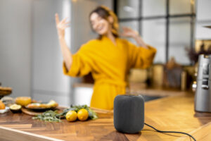 Woman dancing happily in kitchen beside countertop and speaker while cooking in this Tess Renè Coaching article about everyday joy practices and reconnecting with yourself
