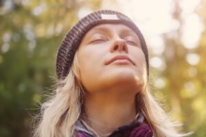 woman breathing calmly outdoors in an article by Tess René Coaching about healthy accountability and healing without shame