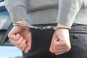 Person standing in handcuffs in this Tess René Coaching article about parent projection, emotional imprisonment, and unresolved childhood wounds repeating in adult relationships