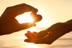 hands offering a small heart in this Tess René Coaching article about being safe to be flawed after guilt and shame