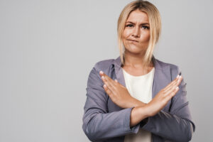 Woman crossing her arms defensively in this Tess René Coaching article about survival mode, emotional protection, and feeling stuck in life