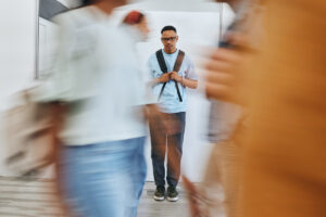 Person standing apart from a crowd in this Tess Renè Coaching article about nervous system responses and emotional sensitivity and feeling overly sensitive.